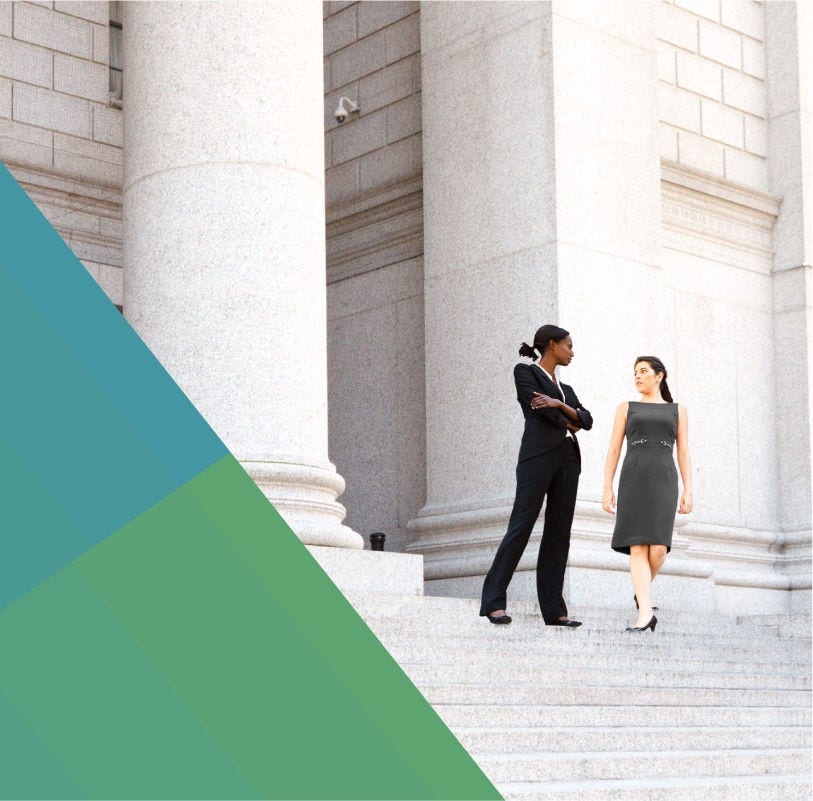 Two women converse on a courthouse's front steps.