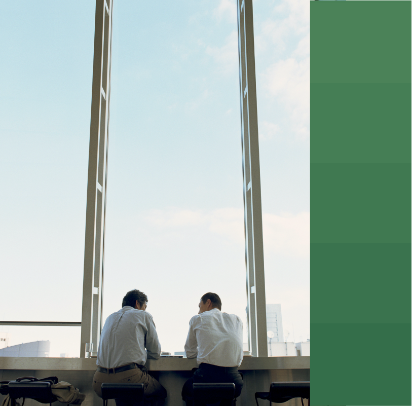 Two male coworkers speaking by a window